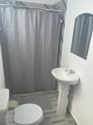 a white bathroom with a toilet and a sink at Plata View Center Habitacion 2D in Monte Plata