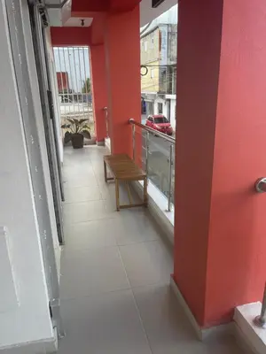 a balcony with a bench and a red wall at Plata View Center Habitacion 2D in Monte Plata