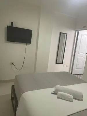 a bedroom with a bed with a tv on the wall at Plata View Center Habitacion 2D in Monte Plata