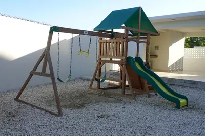 a playground with a swing and a slide at spectrum stay in Baní