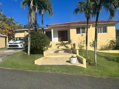 a yellow house with palm trees in front of it at Two residences for one stay in Sosua in Sosúa