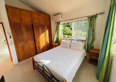 a bedroom with a bed and a large window at Two residences for one stay in Sosua in Sosúa