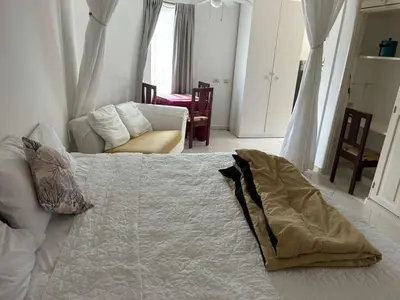 a bedroom with a bed and a couch and a chair at Two residences for one stay in Sosua in Sosúa