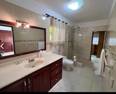 a bathroom with a sink and a toilet and a mirror at Two residences for one stay in Sosua in Sosúa