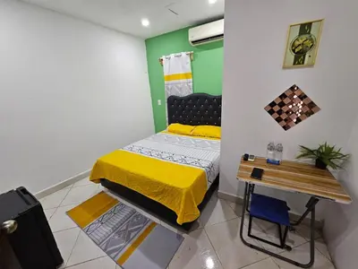 a small bedroom with a bed and a table at W&W Hotel in Las Terrenas