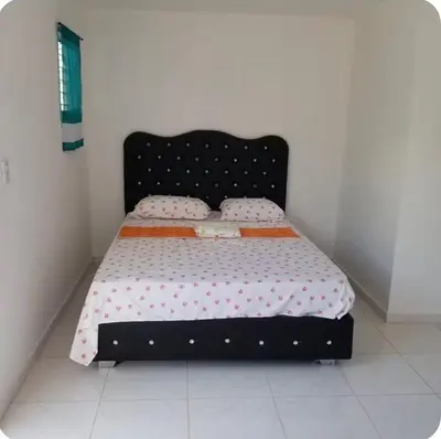 a bed with a black frame in a room at W&W Hotel in Las Terrenas
