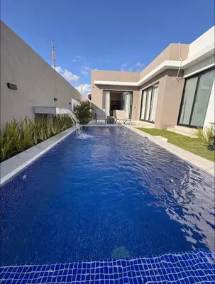 a swimming pool in front of a house at Luxury Caribbean Oasis in La Romana