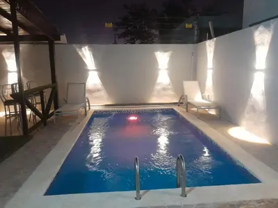 a swimming pool with two chairs and a red ball in it at Naime 3 Bristol villa in San Pedro de Macorís