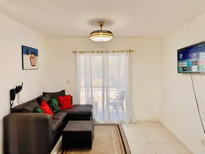 a living room with a couch and a window at Ocean View Fast Wifi Close to Everything Coffee 2BR in La Cana