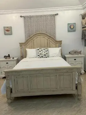 a bedroom with a large white bed with two tables at Los Patos Beach Rooms in Colorado