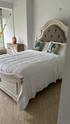 a bedroom with a large white bed with pillows at Los Patos Beach Rooms in Colorado