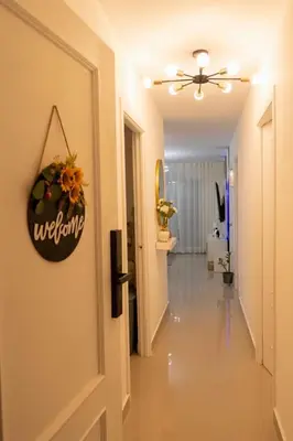 a hallway with a door with a welcome sign on it at Beautiful apartment on the 2nd floor in Boca Residence