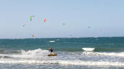 a person on a surfboard in the ocean at Cozy Garden Oasis Steps to the Beach in Cabarete
