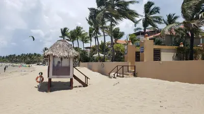 a sign in the sand on a beach at Cozy Garden Oasis Steps to the Beach in Cabarete
