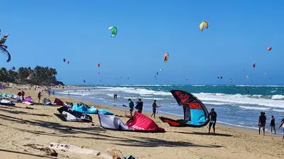 a group of people on a beach flying kites at Cozy Garden Oasis Steps to the Beach in Cabarete