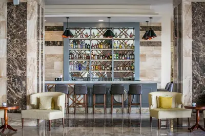 a bar in a restaurant with chairs and a counter at Majestic Mirage Punta Cana, All Suites – All Inclusive in Punta Cana