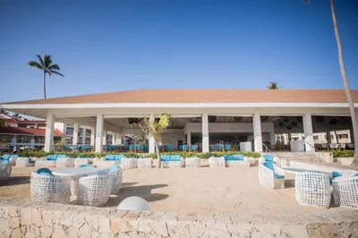 a group of chairs and tables in front of a building at Majestic Mirage Punta Cana, All Suites – All Inclusive in Punta Cana