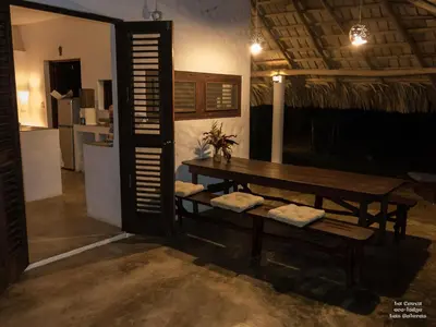 a table and bench in a room with a kitchen at La Cueva Eco-Lodge in Las Galeras