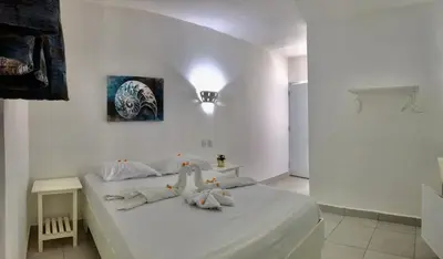 a white bedroom with a bed with stuffed animals on it at Albergo El Pulpo, Bayahíbe in Bayahibe