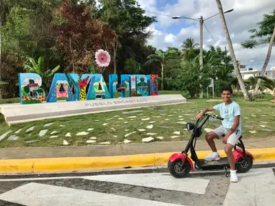 a young boy riding a scooter on a street at Albergo El Pulpo, Bayahíbe in Bayahibe