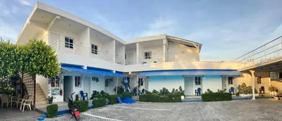 a large white building with blue accents at Albergo El Pulpo, Bayahíbe in Bayahibe