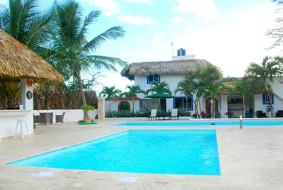 a swimming pool in front of a house at Nuovo Hotel Playa Catalina in La Romana