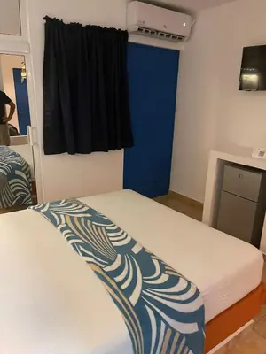 a bedroom with two beds and a blue wall at Nuovo Hotel Playa Catalina in La Romana
