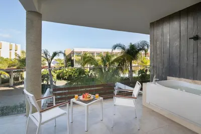 a balcony with a tub and a table and chairs at Dreams Onyx Resort & Spa - All Inclusive in Punta Cana