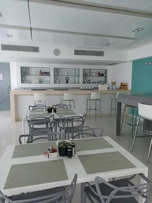 a room with tables and chairs and a kitchen at Lincoln Suite in Santo Domingo