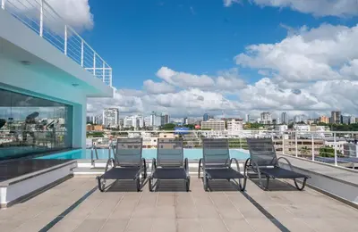 a balcony with chairs and a view of a city at Lincoln Suite in Santo Domingo