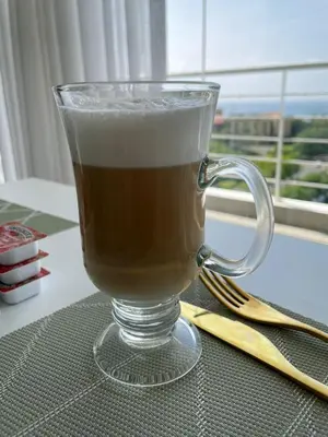 a glass mug of coffee sitting on a table at Lincoln Suite in Santo Domingo