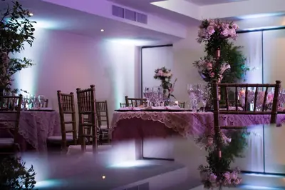 a dining room with a table and chairs and flowers at W&P Santo Domingo in Santo Domingo
