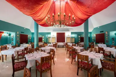 a dining room with white tables and chairs and a chandelier at Viva Dominicus Palace by Wyndham, A Trademark All Inclusive in Bayahibe
