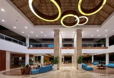 a lobby with a large chandelier and blue couches at Viva Dominicus Palace by Wyndham, A Trademark All Inclusive in Bayahibe