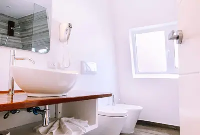 a white bathroom with a sink and a toilet at Puerto Plaza Las Terrenas in Las Terrenas