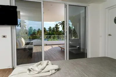 a room with a bed and a view of a balcony at Puerto Plaza Las Terrenas in Las Terrenas
