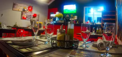 a table with wine glasses on top of a bar at Hotel Casa Jum in Santiago de los Caballeros