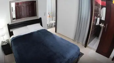 a bedroom with a blue bed and a mirror at Hotel Casa Jum in Santiago de los Caballeros