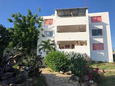 a white building with plants in front of it at Corales Punta Rusia in Punta Rucia
