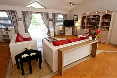 a living room with white furniture and red pillows at Villa Talanquera in Las Galeras
