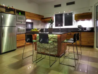 a kitchen with a island with bar stools at Villa Salamandra in Las Galeras