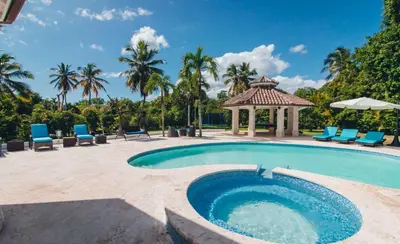 a swimming pool with a gazebo and chairs at Villa Maud in La Romana
