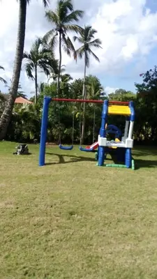a playground with a swing set in a park at Villa Maud in La Romana
