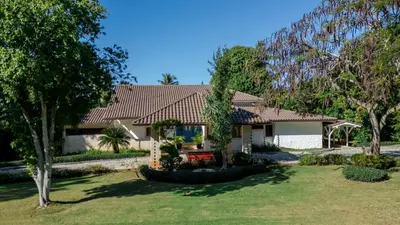a house with a red roof and a yard at Villa Maud in La Romana
