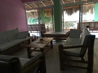 a living room with couches and tables and windows at Casa Altea in Santa Bárbara de Samaná