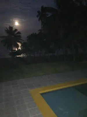 a pool at night with the moon in the background at Casa Altea in Santa Bárbara de Samaná