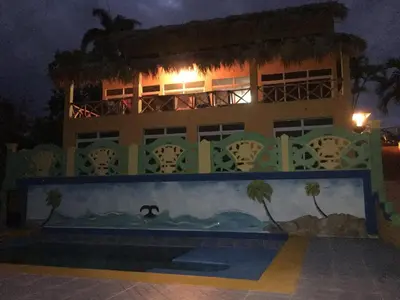 a building with a painting on the side of it at night at Casa Altea in Santa Bárbara de Samaná