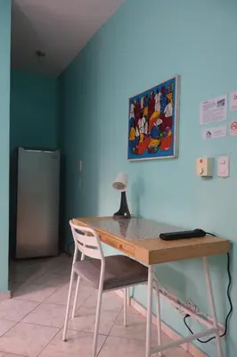 a desk with a chair and a table and a painting at Casa Azul - Apartment in San Felipe de Puerto Plata