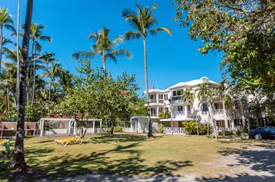 a view of the villas from the beach with palm trees at Amazing Apartments, A-Juan Dolio, El Bonito II in Juan Dolio