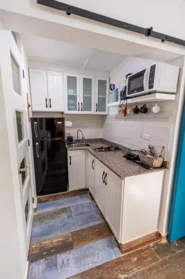 a kitchen with white cabinets and a black refrigerator at Amazing Apartments, A-Juan Dolio, El Bonito II in Juan Dolio